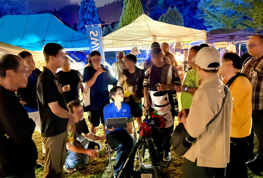 イベント会場で電子観望の実演を囲む参加者たち